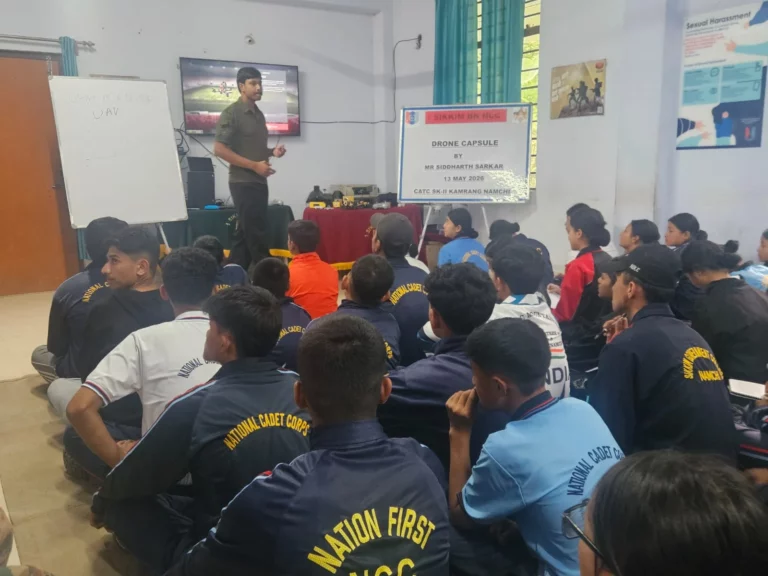 Trainer presenting drone material to a large group of NCC cadets seated in the training hall