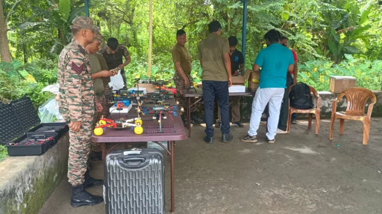 Trainer setting up drone equipment on a table with an army officer at the Kancharapara airfield
