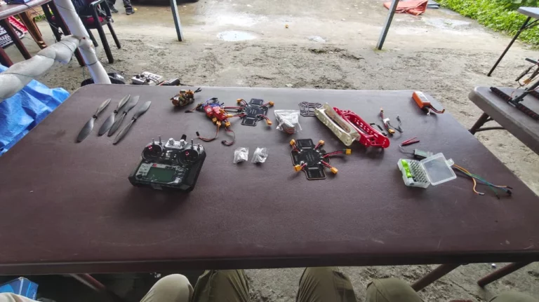 FPV drones and equipment laid out on a table at Kancharapara
