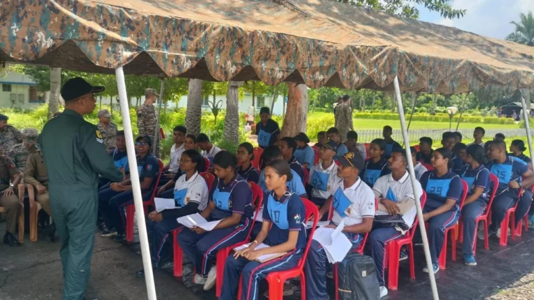 Instructor briefing seated cadets under camouflage netting