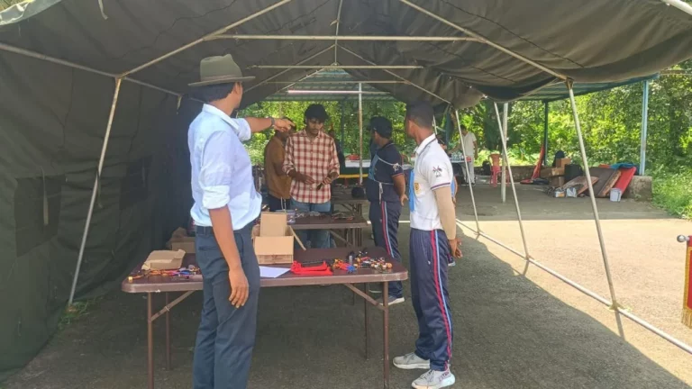 Trainer presenting to cadets beside an equipment table under the tent