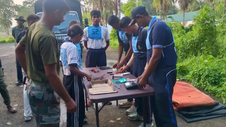 Participants working on drone equipment at an outdoor table